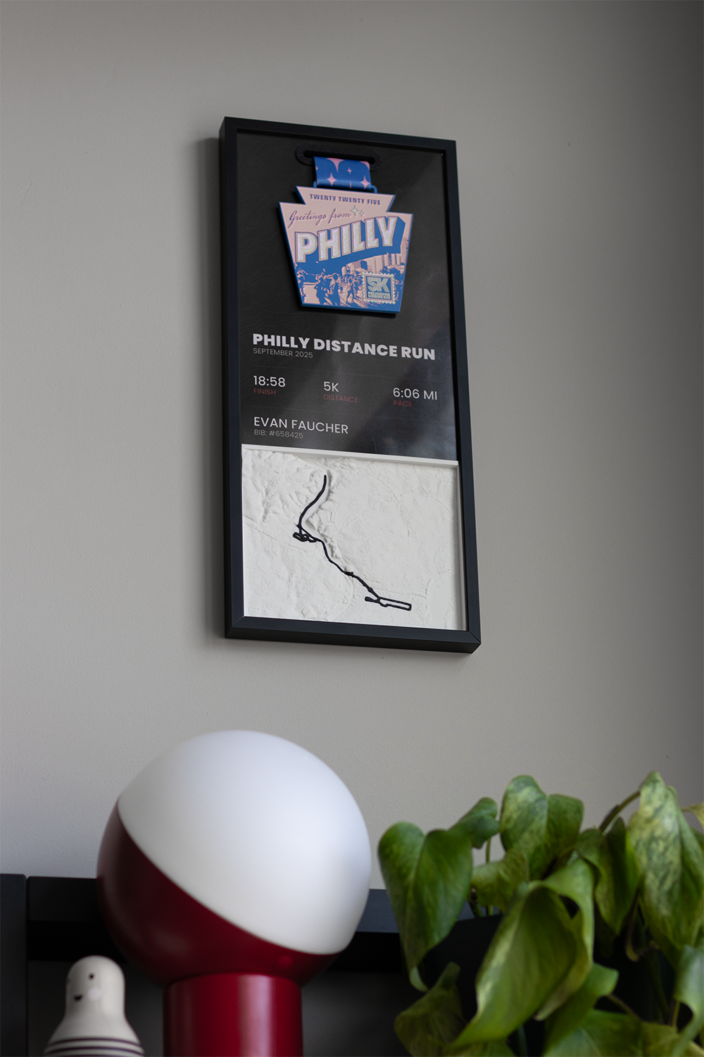Example race panel with medal, stats and 3D course map hanging on a wall